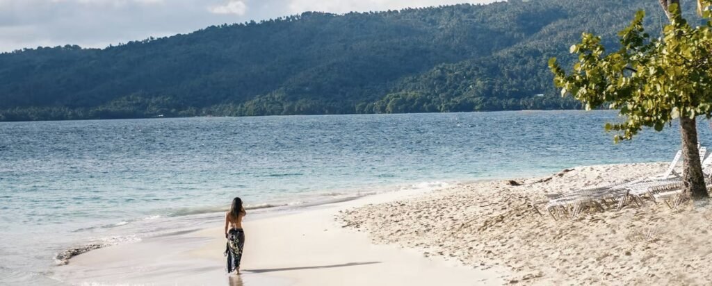Un refugio en el paraíso

Hoy en día, Samaná, con frecuencia abreviada para referirse a toda la península, está bien conectada por tierra y aire, sin embargo, sigue siendo el paradisíaco y remoto escape de playas salvajes, plantaciones de cocos y selvas tropicales de República Dominicana. Sus montañas ondulantes y valles forman los ríos cristalinos que desembocan en el Atlántico mientras se precipitan hacia brillantes playas de arena blanca que se extienden cientos de kilómetros alrededor de la costa rocosa de la península. Es como si las aproximadamente 1,500 ballenas jorobadas que visitan la Bahía de Samaná cada año, apreciasen este esplendor natural tanto como los visitantes.

Estos mamíferos gigantes regresan cada año a este rincón especial de República Dominicana para aparearse, dar a luz y disfrutar de este glorioso paisaje tropical. Además de las excursiones estacionales de avistamiento de ballenas en barco en la pintoresca Bahía de Samaná, hay más aventuras ecoturísticas: bodyboarding y kitesurfing en Las Terrenas; senderismo, observación de aves y espeleología o cuevas en el Parque Nacional Los Haitises; barranquismo o cabalgatas para llegar a la cascada El Limón; y paseos en barco a las magníficas playas de arena blanca, en la base de acantilados de 90 metros, o a la costa de la isla de Cayo Levantado.

Los piratas utilizaban sus frondosos bosques de palmeras, playas aisladas y cuevas ocultas como escondites, mientras que las tropas europeas y haitianas se disputaban las profundas aguas de su bahía.